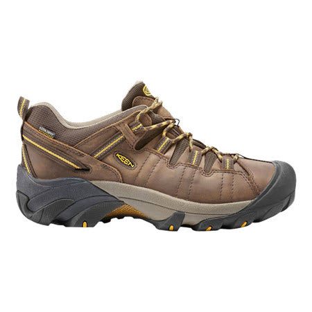 A brown and gray KEEN TARGHEE II CASCADE BROWN/GOLDEN YELLOW - MENS hiking shoe with a sturdy, rugged design, yellow accents, detailed stitching, and an aggressive outsole to tackle any terrain by Keen.