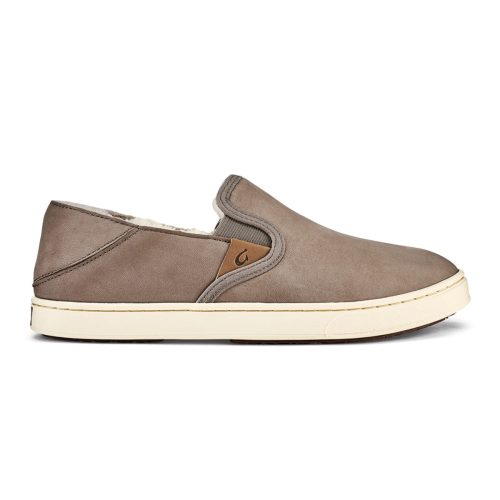 Tan slip-on shoe with a white sole, crafted from waterproof nubuck leather and featuring a small brown logo tag on the side.  Becomes:  OLUKAI PEHUEA HEU TAUPE GREY/TAUPE GREY - WOMENS by Olukai with a white sole, crafted from waterproof nubuck leather and featuring a small brown logo tag on the side.