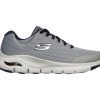 A SKECHERS ARCH FIT GRAY/NAVY - MENS with a white sole, black laces, and a logo on the side. The Skechers design features breathable mesh material, cushioned support, and enhanced arch support for comfortable walking shoes.