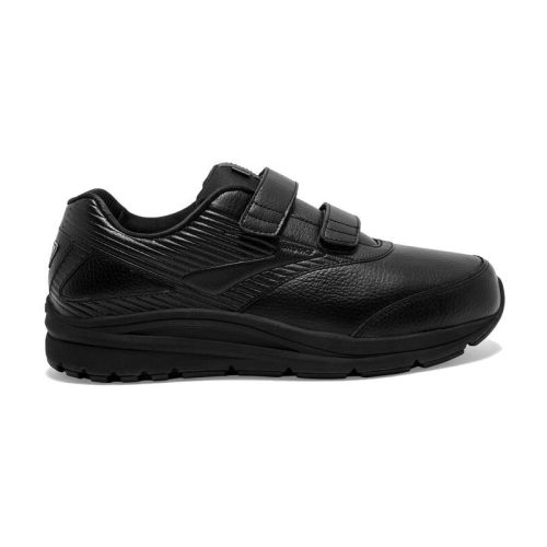 A black BROOKS ADDICTION WALKER V STRAP 2 BLACK - MENS sneaker with a chunky sole and two Velcro straps over the top for closure, featuring runner-tech cushioning for ultimate comfort, displayed against a white background.