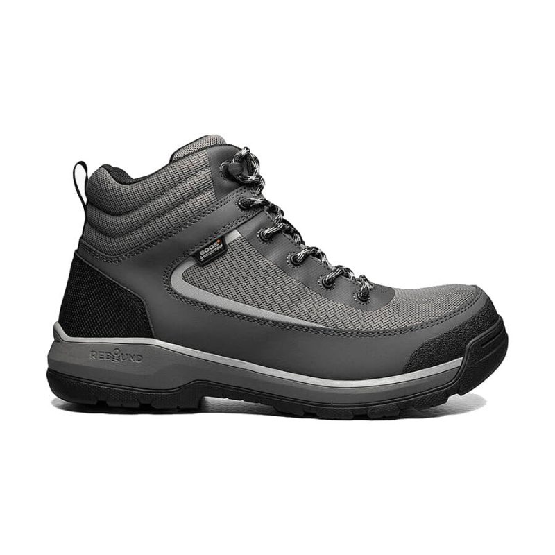 A Bogs BOGS SHALE MID SOFT TOE WATERPROOF DARK GRAY - MEN hiking boot with black accents, featuring a high ankle design, lace-up closure, and a durable slip-resistant sole. Perfect for outdoor adventures or hybrid work environments.