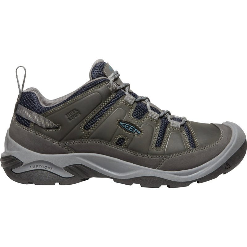 A grey and black outdoor hiking shoe with a rugged sole and blue accents, the Keen KEEN CIRCADIA VENT STEEL - MENS is designed for durability and comfort on tough terrains, featuring a webbing eyelets system for secure lacing.