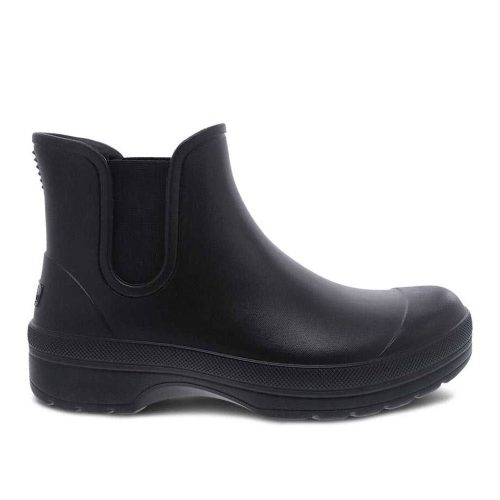 Introducing the Dansko DANSKO KARMEL BLACK - WOMENS: a black, ankle-height boot with arch support featuring a smooth finish, rounded toe, and a slightly raised sole with textured grips for stability. Made with biobased EVA for comfort and durability.