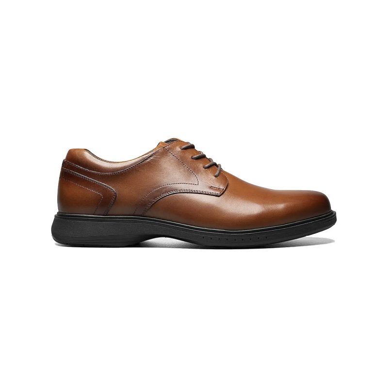 A Nunn Bush NUNN BUSH KORE PRO PLAIN TOE COGNAC - MENS with black outsole and slip-resistant sole, side view.