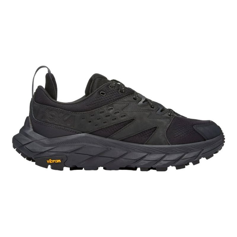 A black trail running shoe with a rugged, textured sole featuring the Vibram Megagrip outsole and the Vibram logo in yellow on the heel, the HOKA ANACAPA BREEZE LOW BLACK/BLACK - MEN by Hoka.