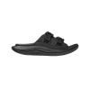 A black recovery slide sandal with two adjustable Ariaprene straps featuring buckle closures, a sugarcane EVA midsole, and a contoured sole: ORA LUXE BLACK/BLACK - ADULT by Hoka.