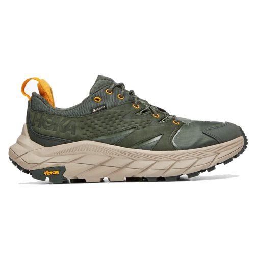 A green and beige running shoe with a thick sole, yellow accents, and a Hoka logo on the side. The shoe features Vibram technology and incorporates recycled polyester for an eco-friendly touch. This is the HOKA ONE ONE ANACAPA LOW GTX DUFFEL BAG/RADIANT YELLOW - MENS.