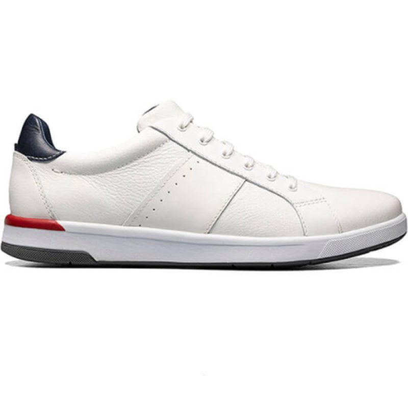 A white low-top Florsheim FLORSHEIM CROSSOVER LACE WHITE - MENS sneaker with a red accent on the heel and a dark blue strip on the back. This Lace to Toe sneaker features white laces and a gray outsole, making it perfect among walking shoes.