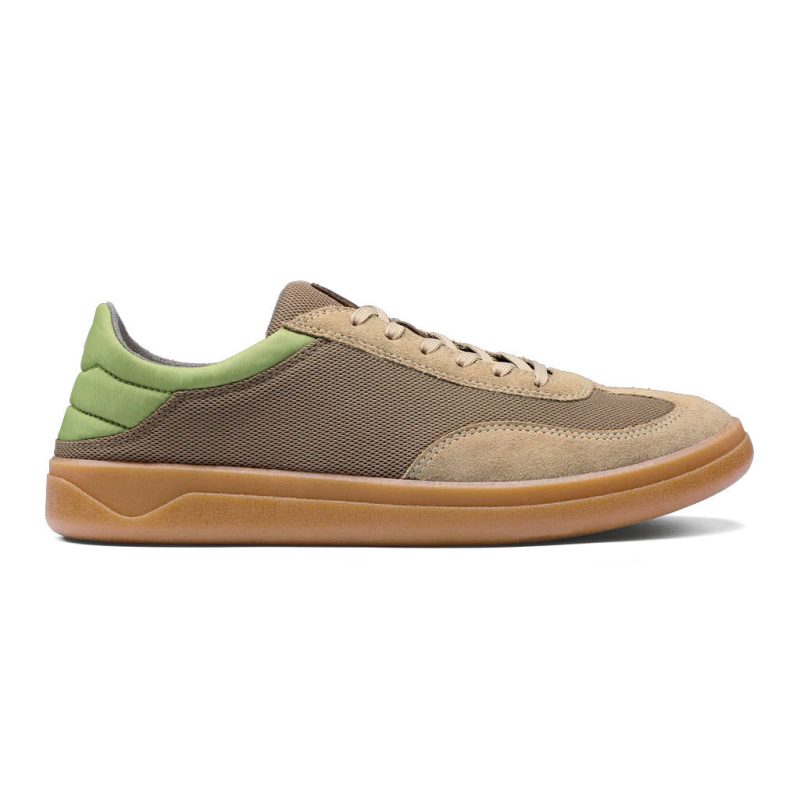 Side view of the Olukai OLUKAI PUNINI CLAY LEMON GRASS - MENS, a casual lace-up nostalgic court sneaker with a beige, green, and brown color scheme, featuring a brown sole and mesh texture on the upper, perfect for embracing the beach lifestyle.