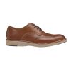 A JOHNSTON & MURPHY UPTON WINGTIP TAN - MENS with decorative perforations, a beige and white sole, and stitching details on a white background, featuring TRUFOAM™ memory foam insoles for added comfort by Johnston & Murphy.