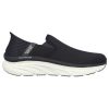 A black slip-on sneaker with a white, thick sole and minimal branding on the side reading "SKECHERS D'LUX WALKER ORFORD BLACK - MENS." Featuring a textured back, breathable mesh upper, and Air-Cooled Memory Foam for comfort. These Skechers Hands Free Slip-ins are perfect for effortless wear.