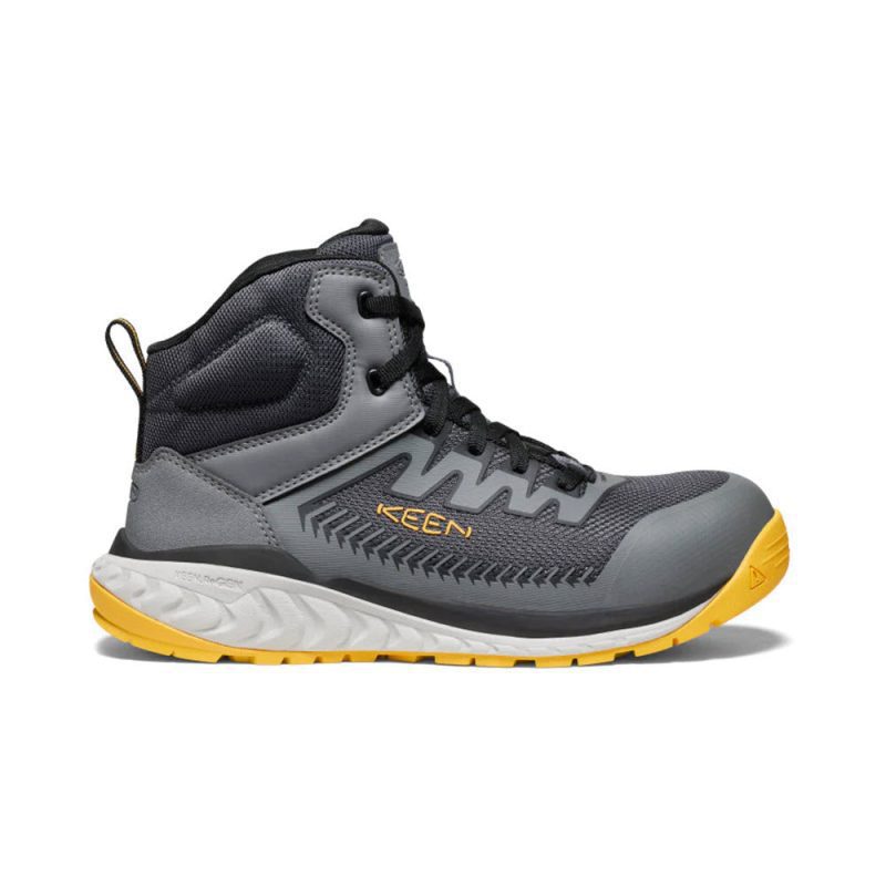 A grey and black high-top athletic shoe with yellow accents, featuring a lace-up design and sturdy tread on the sole, branded with "KEEN" on the side, offering energy-returning comfort for enhanced athletic performance is the KEEN CT ARAVADA MID SNEAKER GREY YELLOW - MENS by Keen.