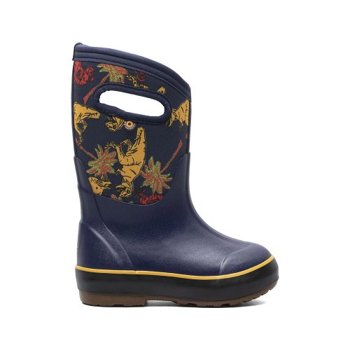 A single blue children's boot with yellow dinosaurs and palm trees on the upper portion, featuring cut-out handles and a yellow stripe above the sole. The Bogs BOGS CLASSIC II DINO DODO NAVY MULTI - KIDS promotes healthy foot growth by encouraging natural foot movement.