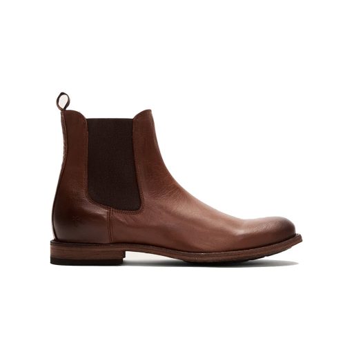 Handcrafted brown leather FRYE TYLER CHELSEA PULL ON BOOT COGNAC - MENS with a dark elastic side panel and a pull tab, on a wooden sole, viewed from the side.