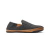 A gray slip-on shoe with stitched detailing, a brown rubber sole, and a soft inner lining made of genuine shearling for nonstop comfort, viewed from the side. This is the Olukai OLUKAI HANOHANO CANVAS SHEARLING SLIPPER DARK SHADOW - MENS.