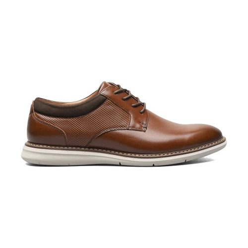 A Nunn Bush brown leather lace-up NUNN BUSH CHASE PLAIN TOE OXFORD COGNAC MULTI - MENS with a textured midsection and white rubber sole, featuring the advanced comfort of the BLOOM footbed, viewed from the side.