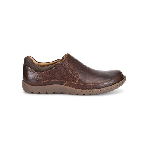 A side view of the BORN NIGEL SLIP ON BROWN - MENS crafted from high-quality brown leather with a textured sole, featuring elastic gores for easy fitting and a visible Born logo on the heel, ensuring both comfort and style.