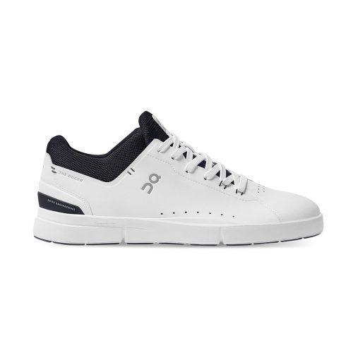 A white athletic shoe with black accents, inspired by Roger Federer's tennis style. The ON THE RODGER ADVANTAGE WHITE/MIDNIGHT - MENS from On Running features a lace-up design, perforations on the side, and branding details.