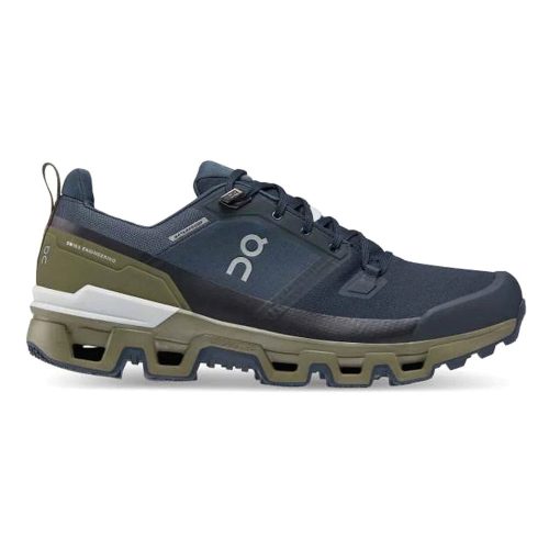 Side view of a navy and olive green athletic shoe with the "On Running" logo on the side, featuring a rugged Missiongrip rubber sole designed for outdoor performance. These ON CLOUDWANDER WATERPROOF MIDNIGHT/OLIVE - MENS from On Running are built for all your outdoor adventures.