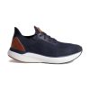 The **Johnston & Murphy Miles Knit Lace Up Oxford Navy - Mens** is a navy blue athletic shoe featuring a white sole, brown accents on the heel, black laces, and a breathable mesh design on its upper section. These fashionable shoes also include an EVA footbed for enhanced comfort.