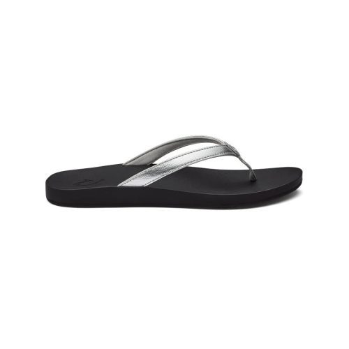 An Olukai OLUKAI PUAWE SILVER - WOMENS sandal with a flat sole, cushy foam footbed, and water-friendly Y-shaped strap, displayed against a white background.