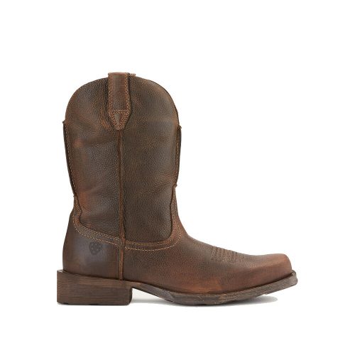 A brown leather western boot with a rounded toe, thick heel, and pull tabs on both sides. The unlined leather ARIAT RAMBLER 11 INCH SQUARE TOE WESTERN BOOT WICKER - MENS from Ariat features visible stitching details, a rugged texture, and offers sneaker-like comfort with its flexible durable outsole.